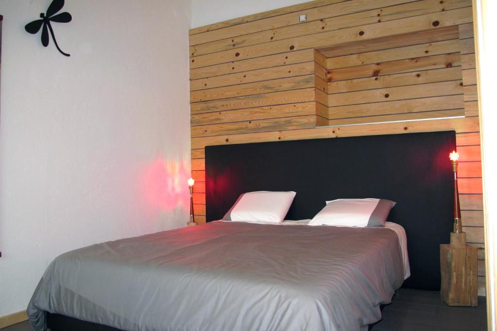 Esneux石站公寓式酒店的一间卧室配有一张大床和木制床头板