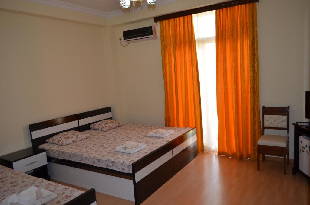 巴统优雷夏酒店的一间卧室配有床和橙色窗帘