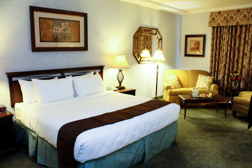弗雷斯诺大学广场酒店的酒店客房设有一张大床和一张沙发。