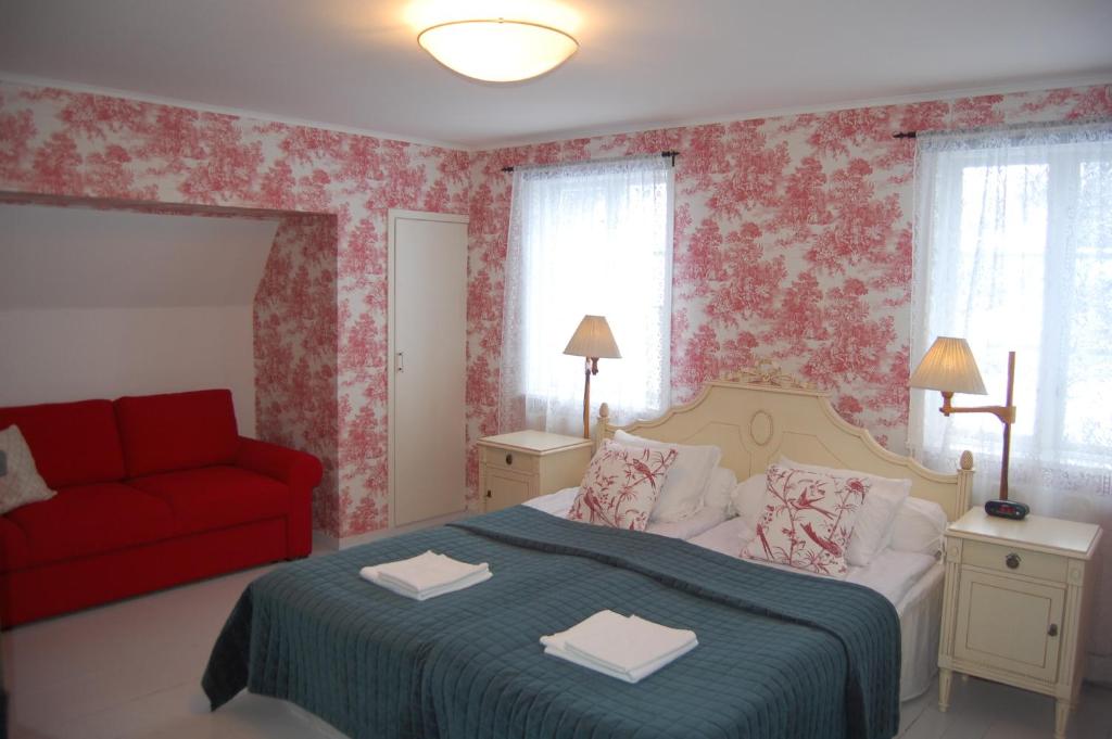 费尔耶斯塔登STF Vickleby Bo Pensionat的一间卧室配有一张床和一张红色的沙发