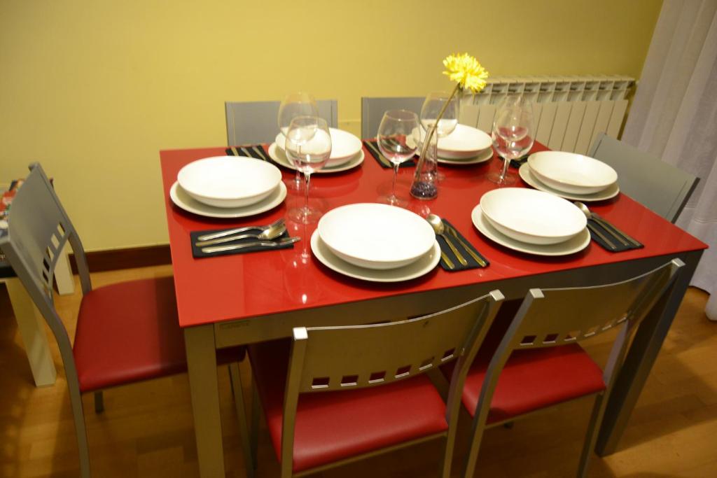 瓜达拉哈拉Apartamento Turistico Dct. Creus的红色桌子,上面放有盘子和酒杯