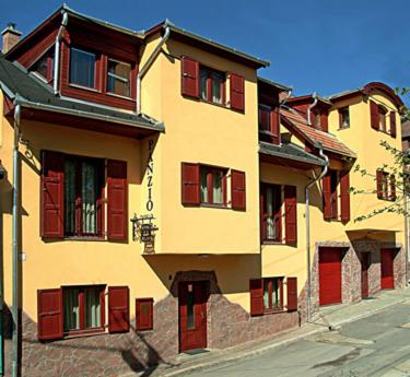 艾斯特根Decsi Vendégház的街上有红色百叶窗的黄色建筑