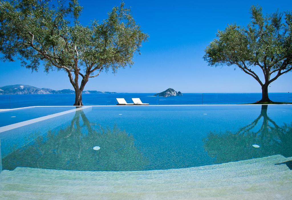 凯里翁吉玛若斯别墅的一座拥有两棵树和蓝色海水的游泳池
