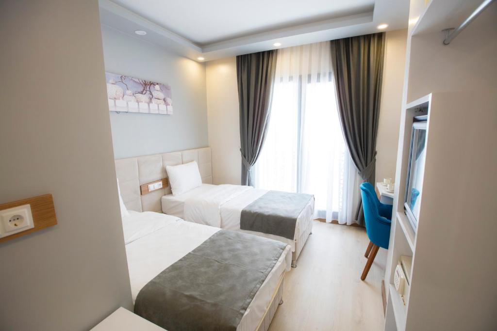 伊斯坦布尔Royal İnci Spa Hotel的酒店客房设有两张床和窗户。