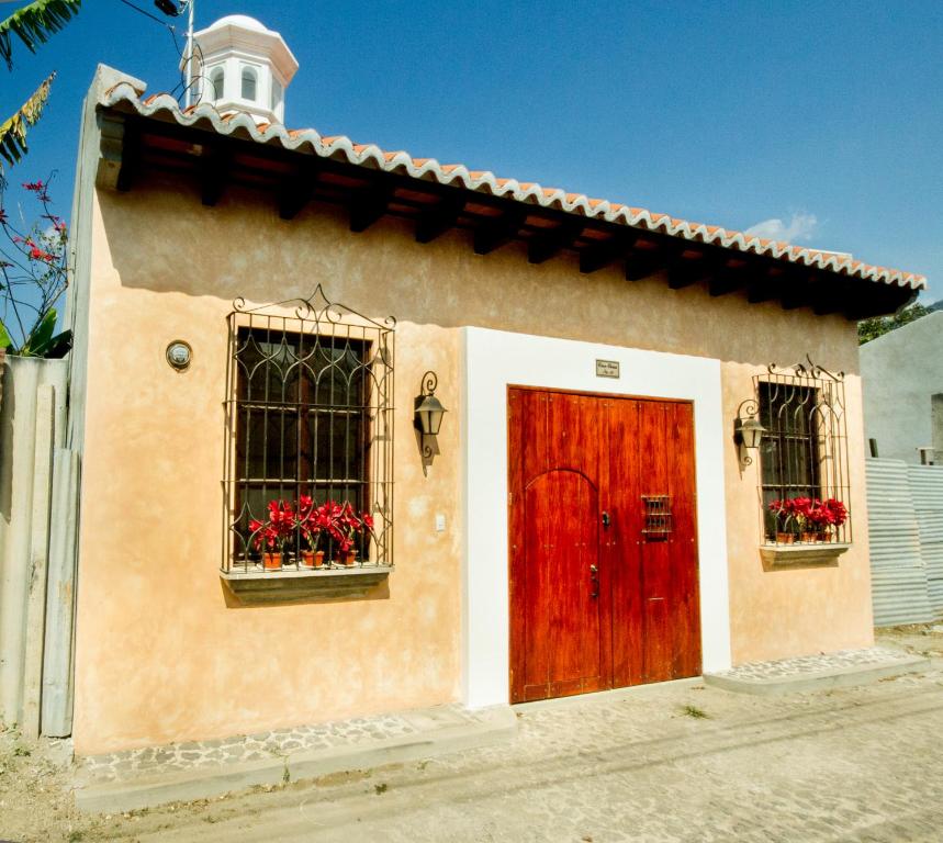 危地马拉安地瓜Casa Elena的一间设有红色门和两个窗户的小房子