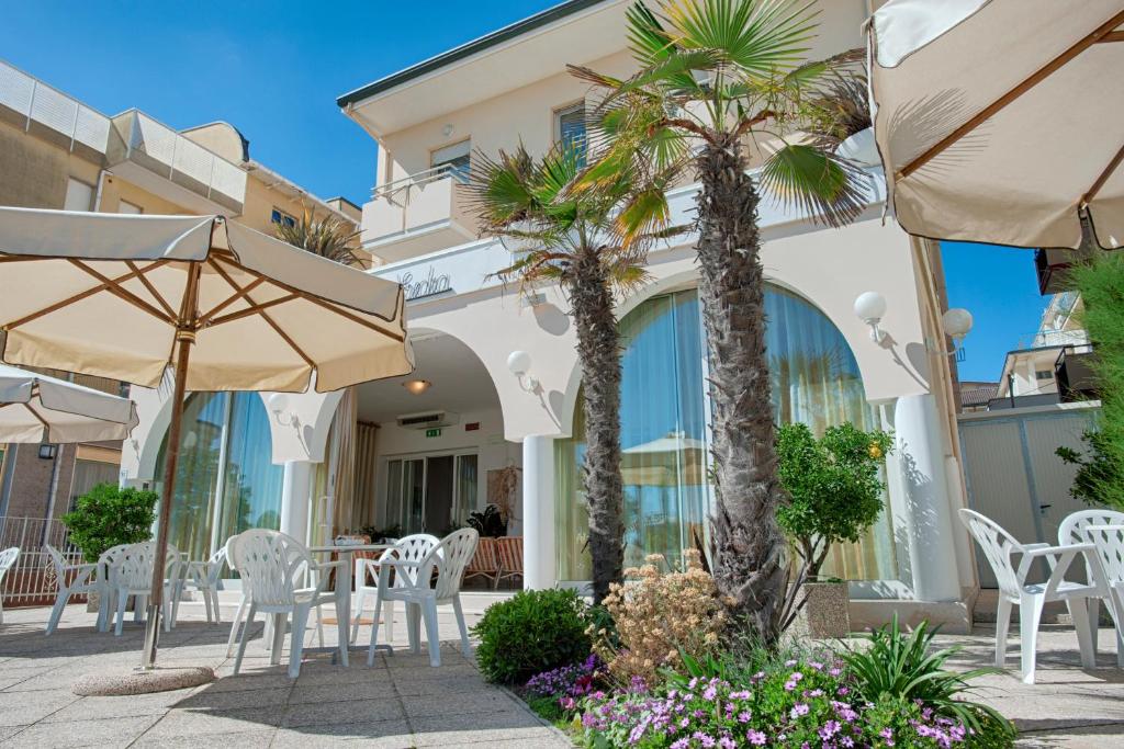 贝拉里亚-伊贾马里纳埃塞德拉别墅酒店的一个带椅子和遮阳伞及棕榈树的庭院