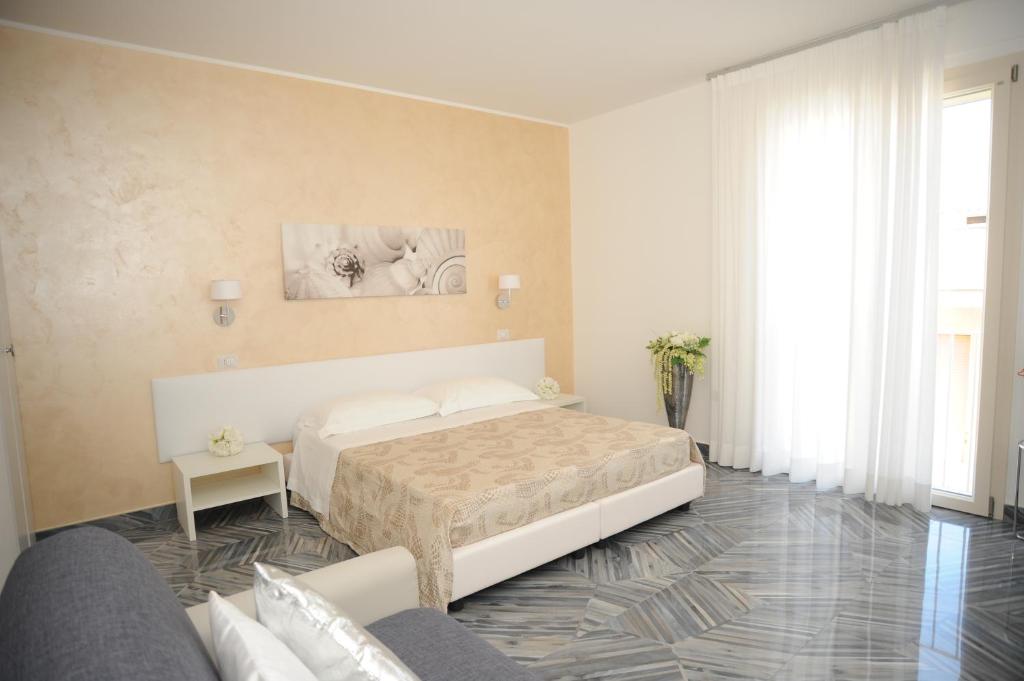 切萨雷奥港Casa Alfieri的白色卧室配有床和沙发