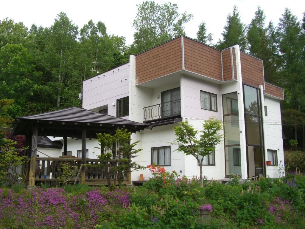 美瑛町Coro Coro的一间白色的大房子,有棕色的屋顶