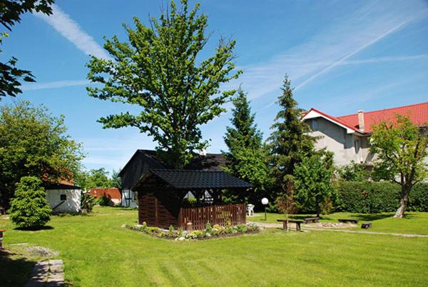 GorzebądzNocleg pod Dębem的院子中一座有长凳和树的建筑
