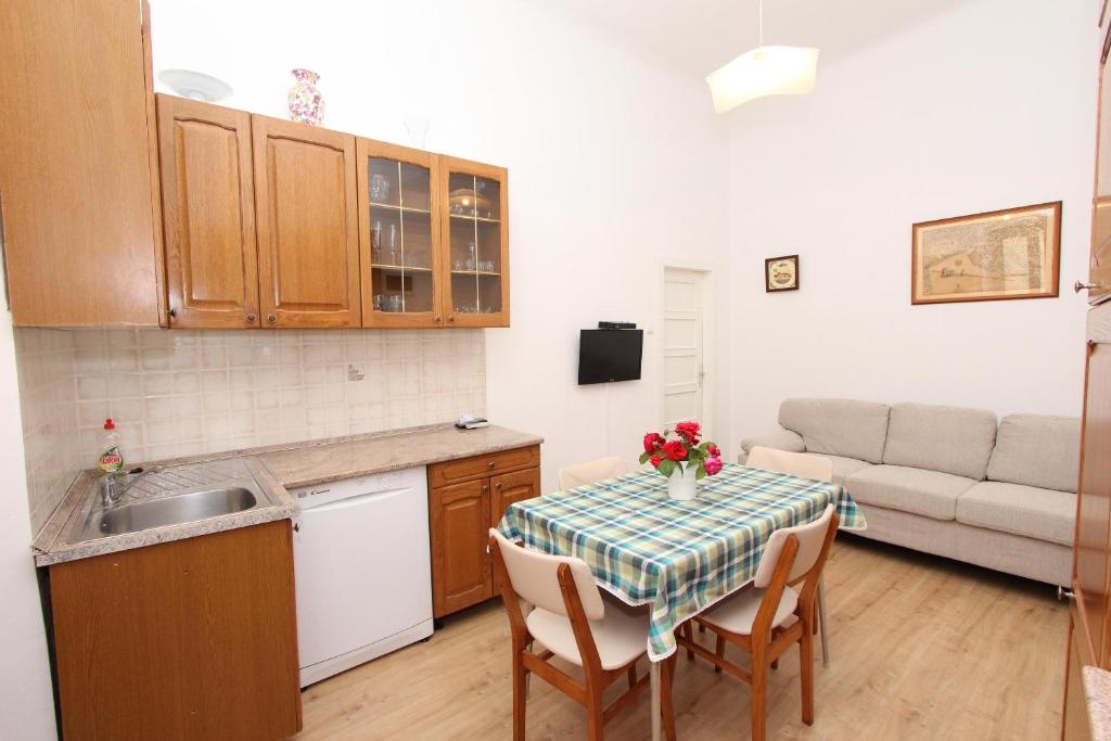 罗维尼里其公寓的一间带桌子和沙发的小厨房