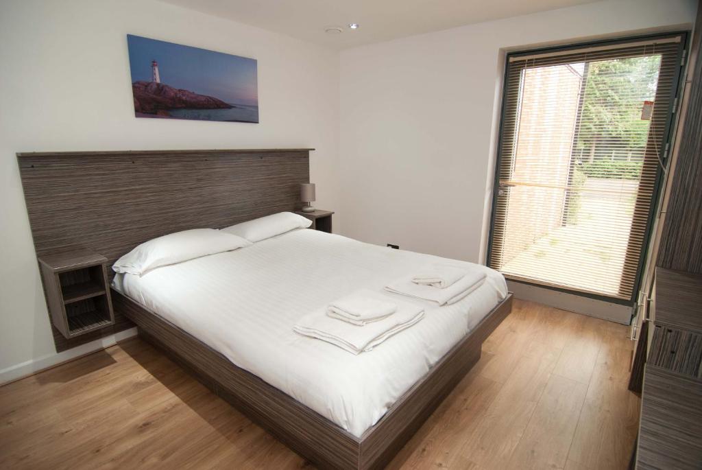 南安普敦南安普敦酒店式公寓的一间卧室设有一张大床和一个大窗户