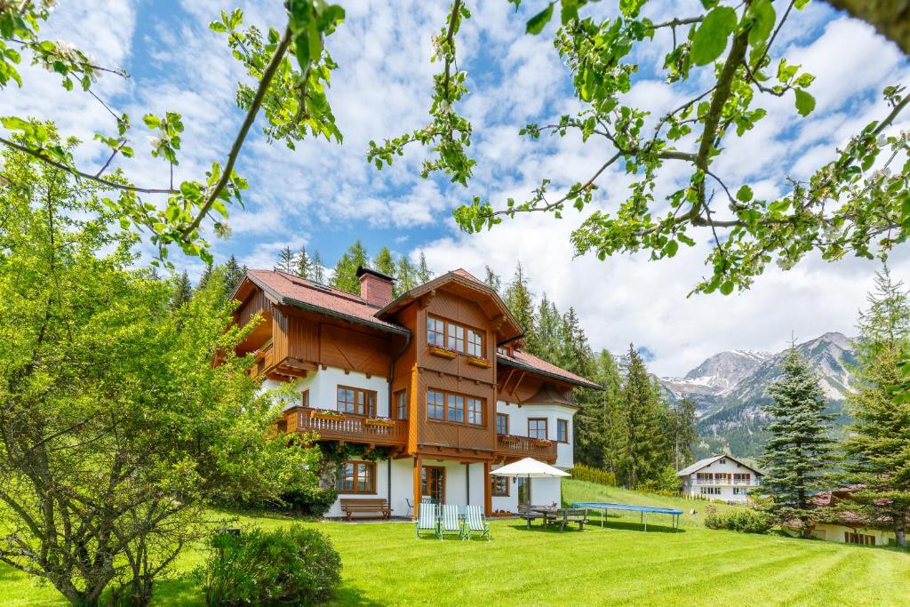 拉姆绍达赫斯坦Landhaus Birgbichler - Apartments mit Bergblick inklusive Sommercard的山丘上以山为背景的房子
