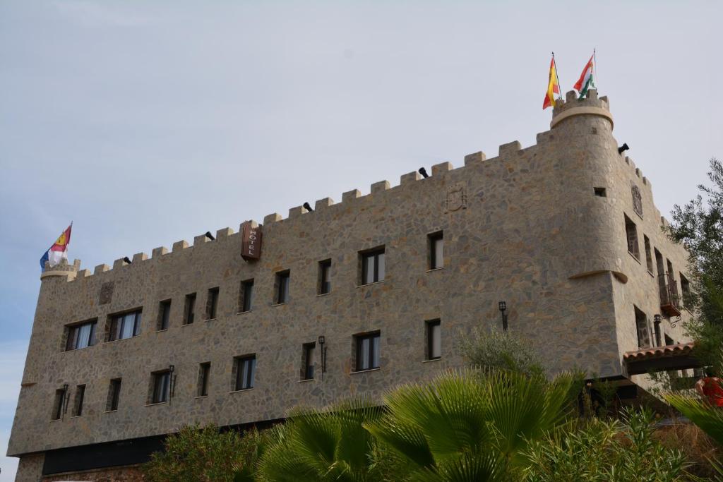 阿尔马登罗萨莱斯乡村餐厅酒店的一面设有窗户的大型砖砌建筑