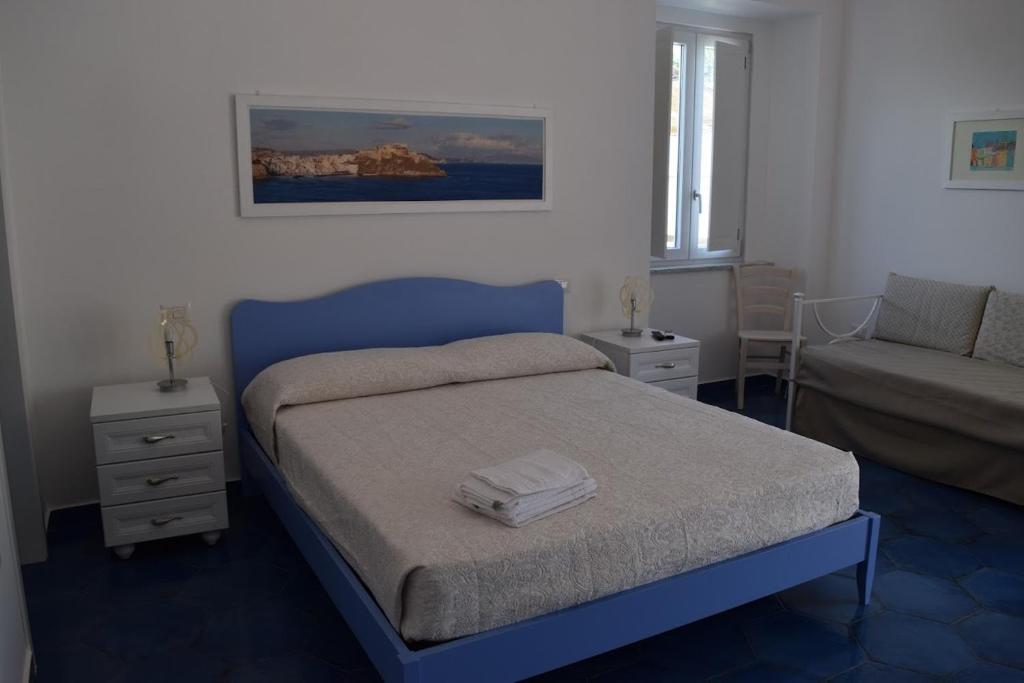 普罗奇达西罗度假屋的一间卧室配有蓝色的床和沙发