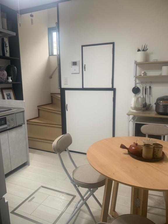 东京仁信小屋的配有桌子和冰箱的厨房