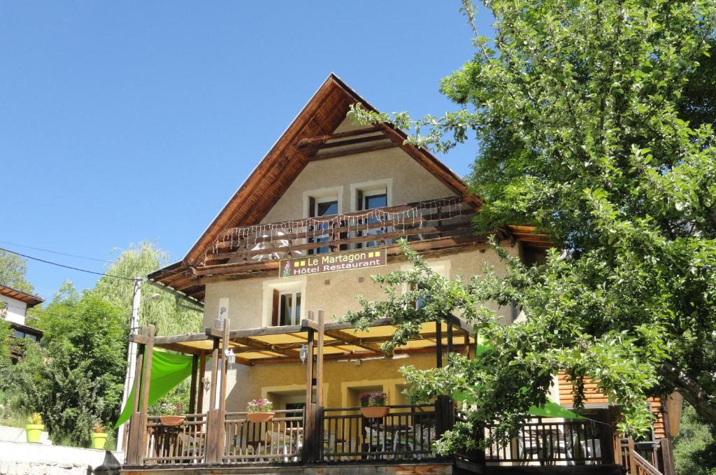 Villars-Colmars马塔贡餐厅酒店的带阳台和树木的大型房屋