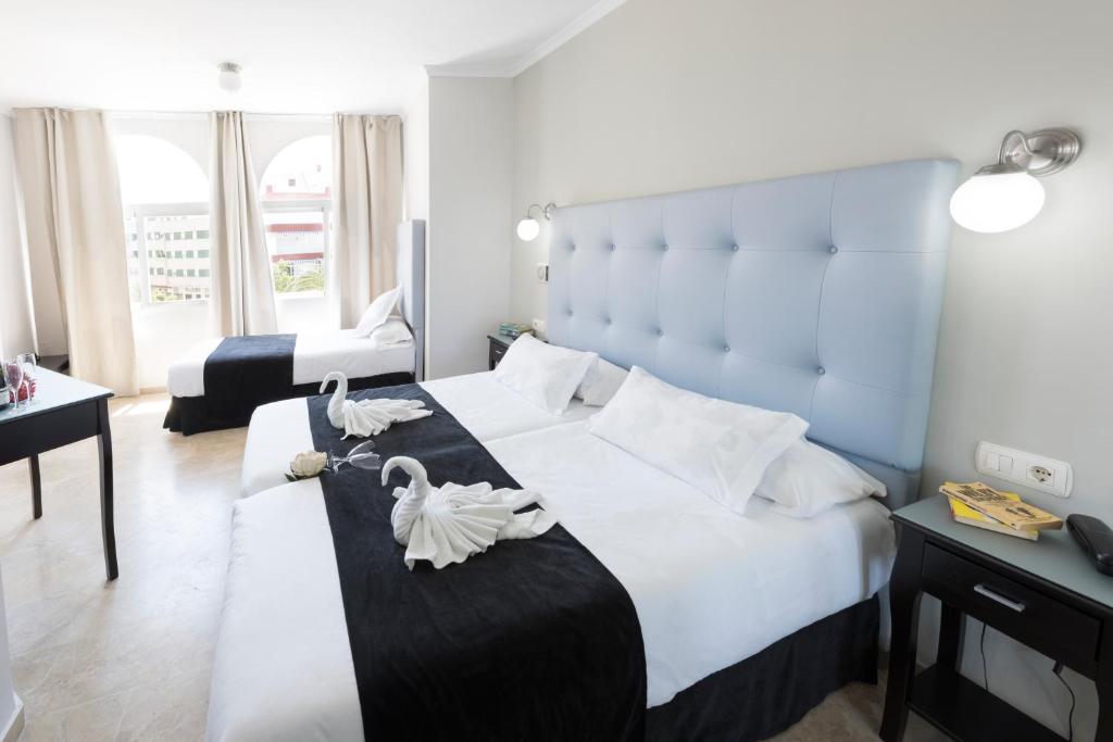 内尔哈托波索查帕瑞尔酒店的一间卧室配有一张大床,上面有天鹅
