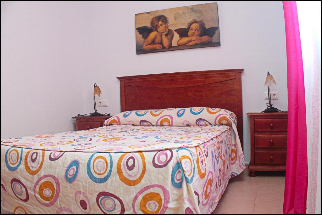科尼尔-德拉弗龙特拉Apartamento Pascual Junquera I的卧室配有一张床,墙上挂有绘画作品