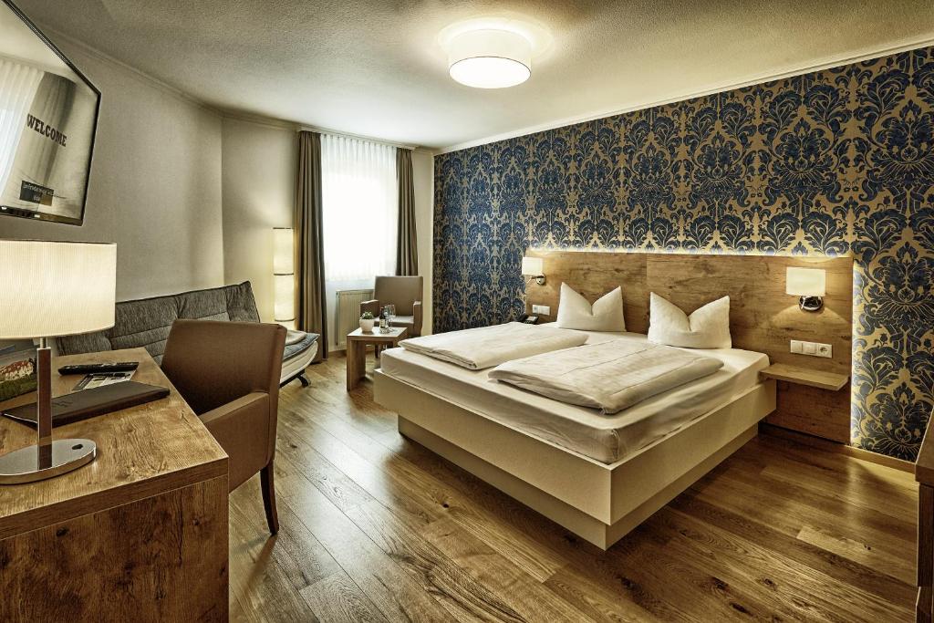 埃登科本德兹普里斯格特酒店的一间卧室配有一张床、一张桌子和一张沙发