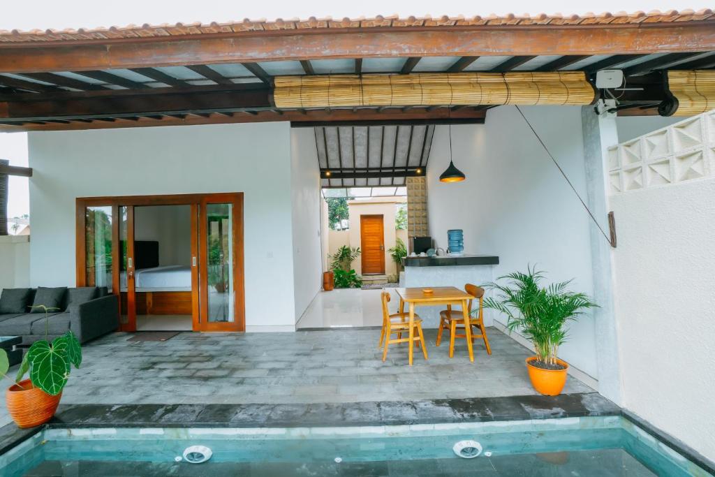 乌布Uma Jala Villa Ubud的房子里有桌子和椅子的露台