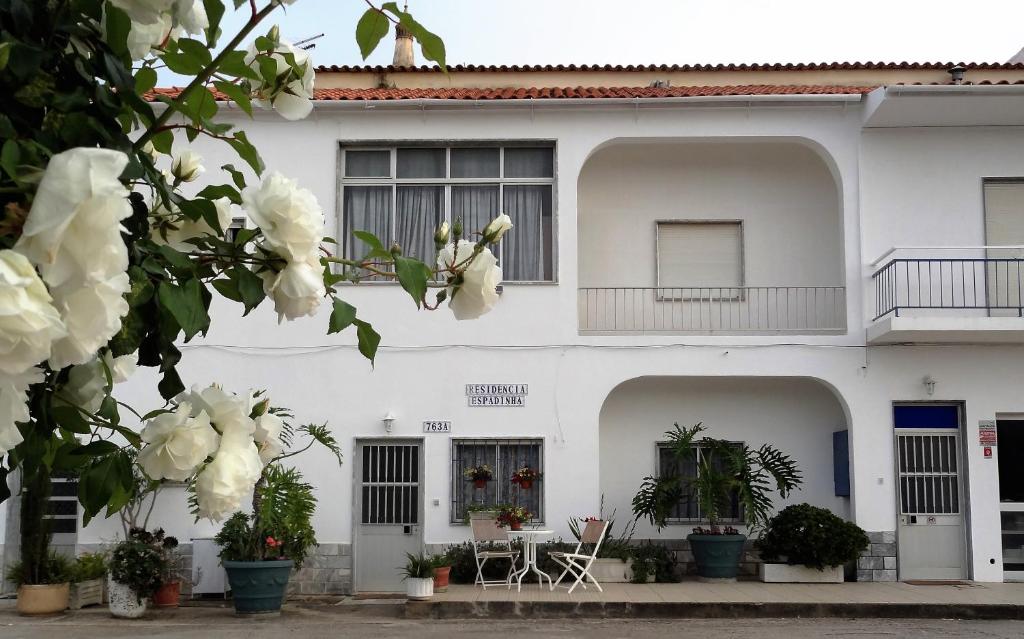 奎特里拉Residencial Espadinha的前面有鲜花的白色建筑