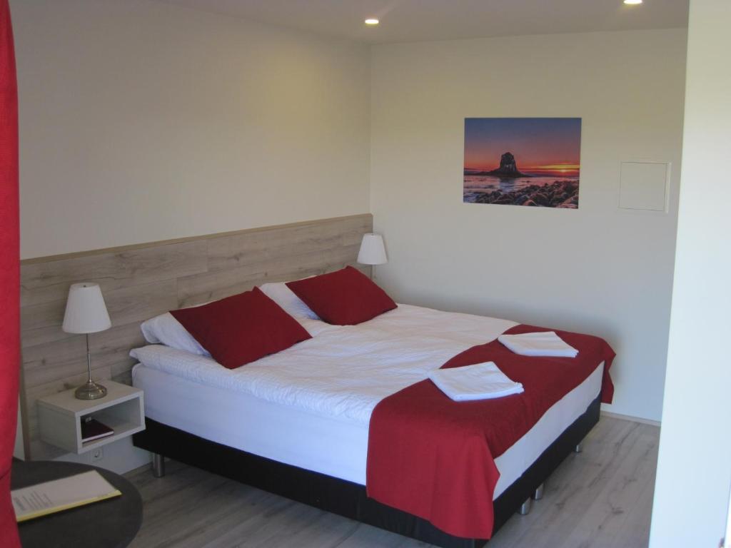 胡萨维克斯卡加尔落日旅馆的一间卧室配有红色和白色床单