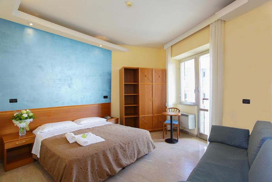 阿尔巴·阿德里亚蒂卡普里斯登酒店的一间卧室配有一张床和一张沙发
