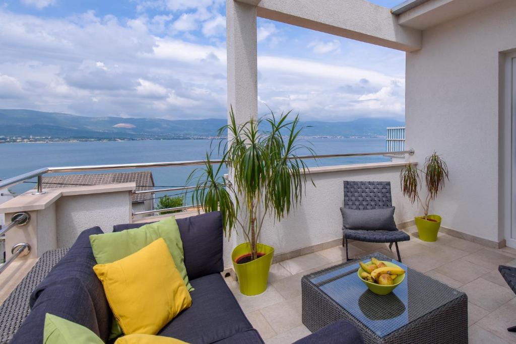 特罗吉尔索罗那公寓的阳台配有沙发,享有水景