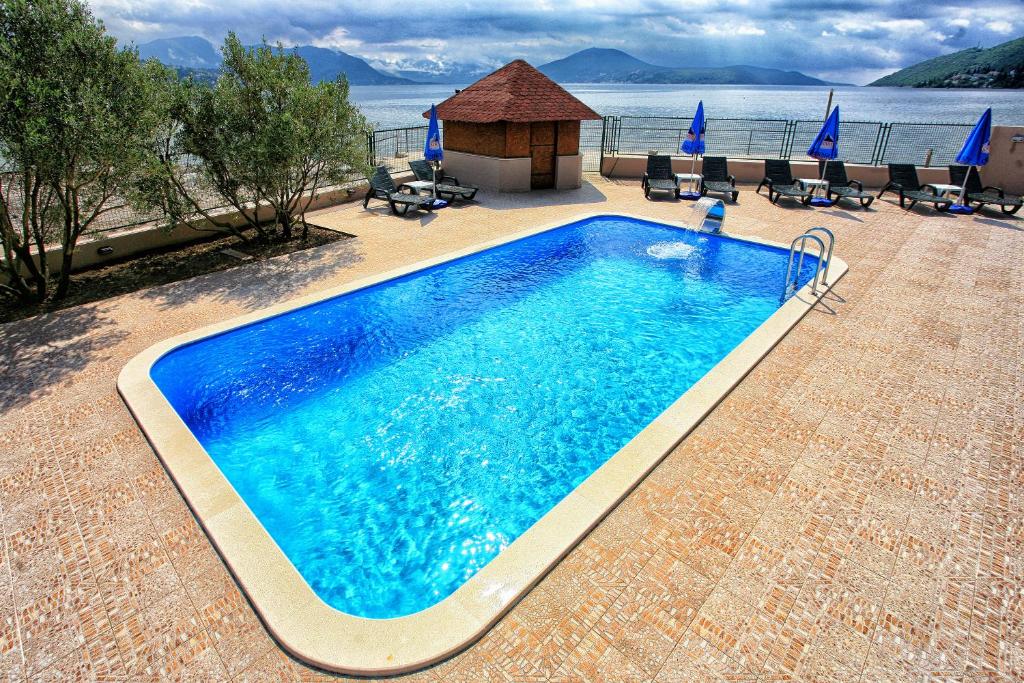 赫尔采格诺维Apartments Maxi Katić的一个带凉亭的大型蓝色游泳池