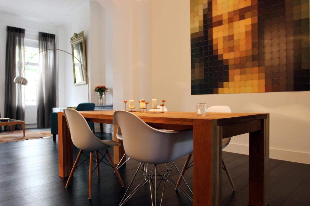 布鲁塞尔Parc Brussels Apartment的一间带木桌和椅子的用餐室