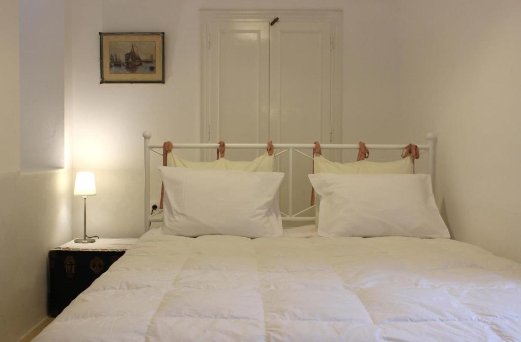 伊兹拉Studio Annezo的卧室内的一张带白色床单和枕头的床