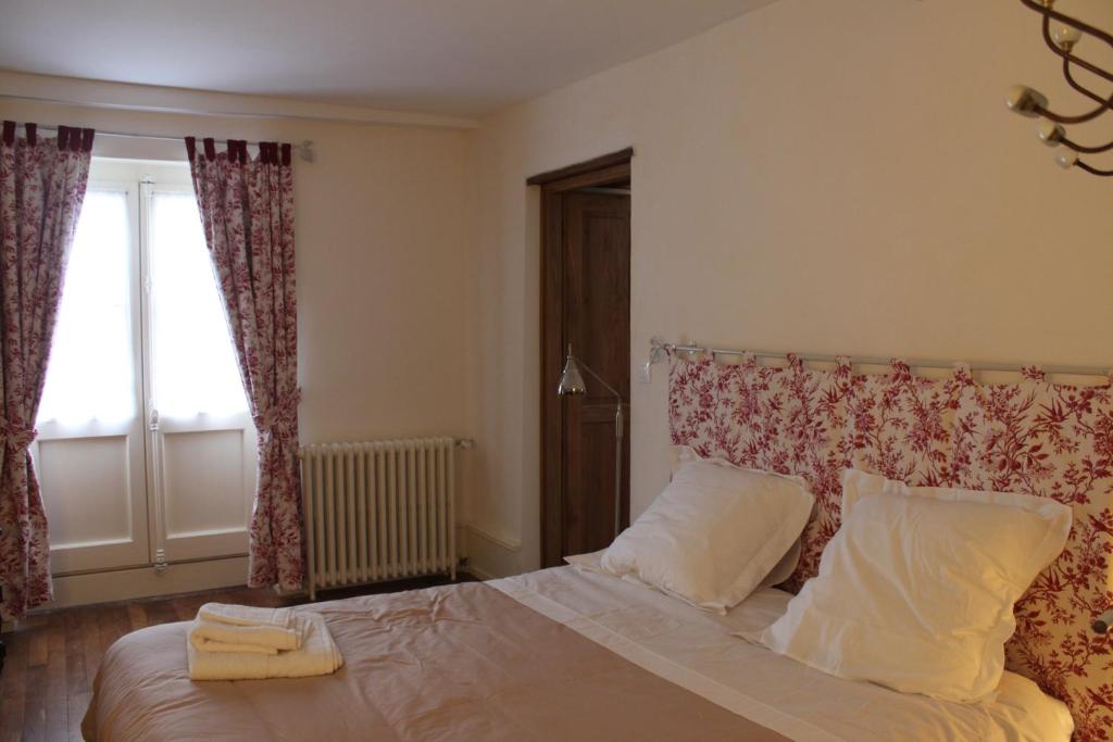 韦兹莱Cellier de l'abbaye - L'Ermitage的一间卧室配有带两个枕头的床和窗户