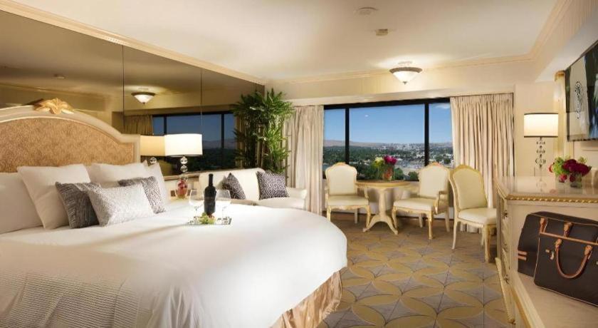 里诺Peppermill Resort Spa Casino的一间带一张白色大床的卧室和一间用餐室