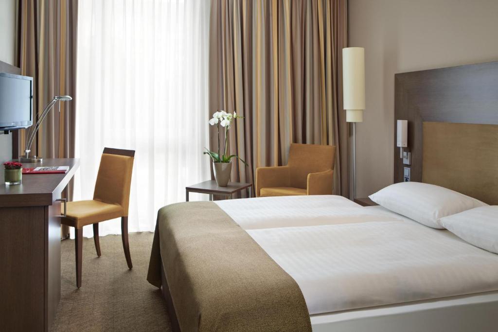 达姆施塔特IntercityHotel Darmstadt的配有一张床和一张书桌的酒店客房