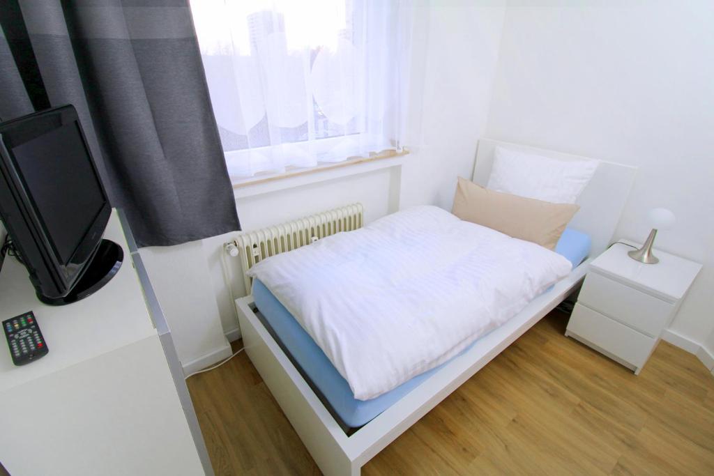 圣奥古斯丁Apartments Sankt Augustin的一间白色的小卧室,配有床和窗户