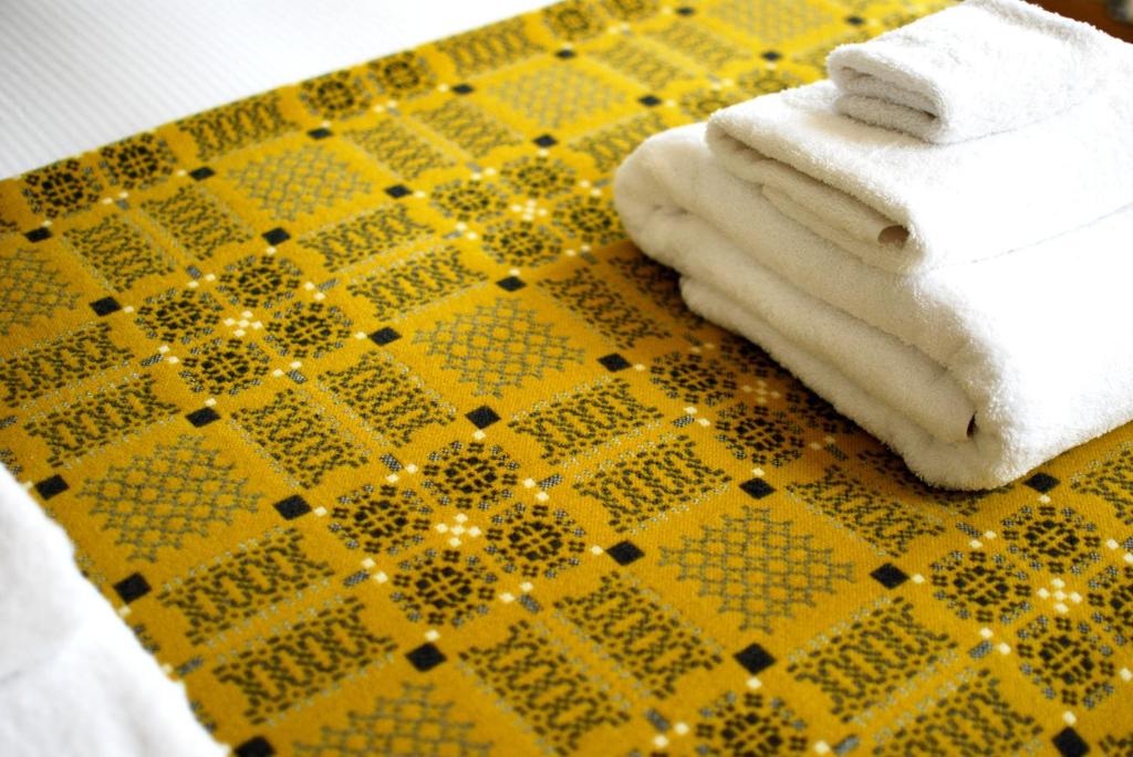 圣大卫Ty Boia Bed & Breakfast的一张黄色和黑色的桌子,上面有毛巾