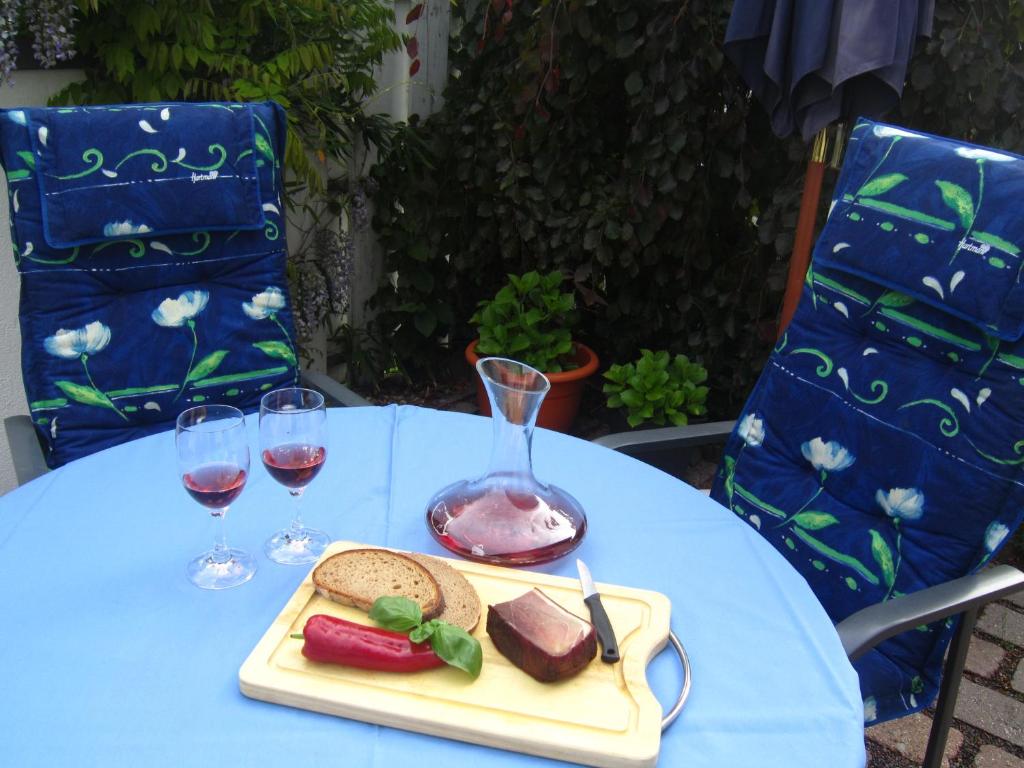 罗特翁特尔里特堡Haus am Südfrüchtegarten的一张桌子,上面放着一盘食物和两杯葡萄酒