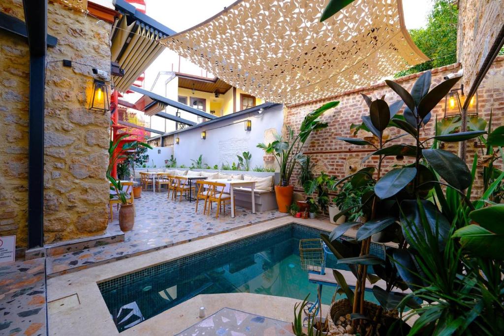 安塔利亚Saye Konak Hotel &#39; Kaleiçi&amp;Oldtown&#39;的户外庭院设有游泳池、桌子和植物