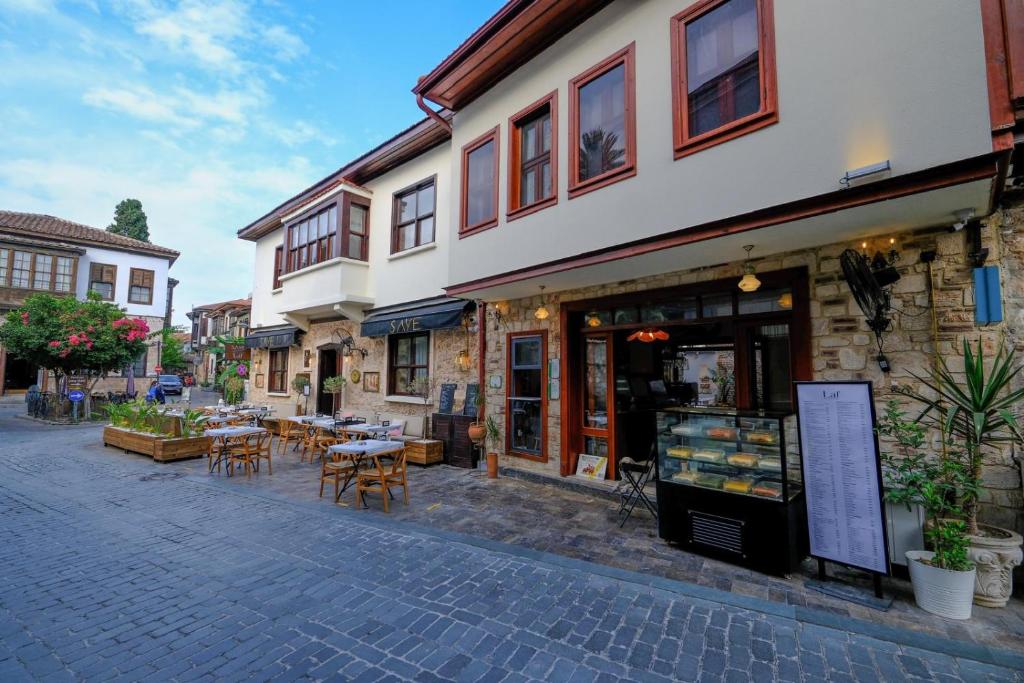 安塔利亚Saye Konak Hotel &#39; Kaleiçi&amp;Oldtown&#39;的街道上设有桌椅的建筑