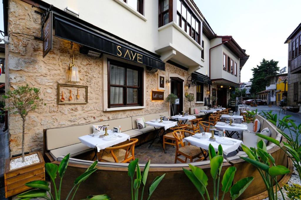 安塔利亚Saye Konak Hotel &#39; Kaleiçi&amp;Oldtown&#39;的大楼外带桌椅的餐厅