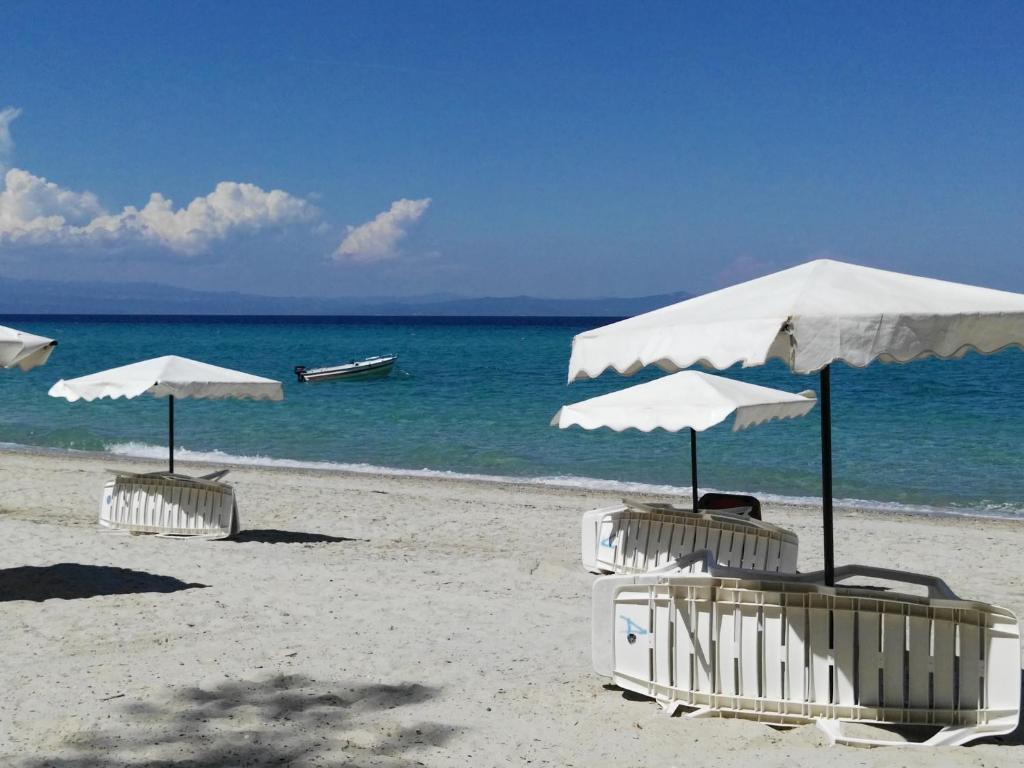 克里皮吉Ariadni -Villas- luxury houses的海滩上的两把遮阳伞和椅子