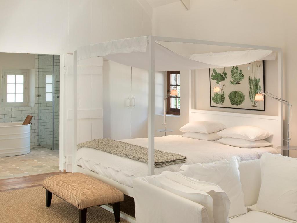 Simondium巴比隆塔楼酒店的白色卧室设有天蓬床和沙发