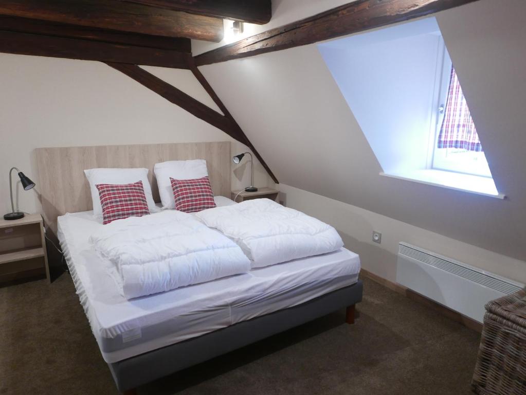 巴尔Le Bacchus的一间卧室配有一张带白色床单的床和一扇窗户。