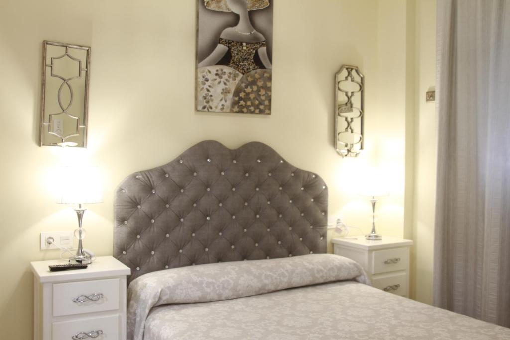 科尼尔-德拉弗龙特拉Hostal Flor De Lis- Lojo的一间卧室配有一张带2个床头柜和2盏灯的床。