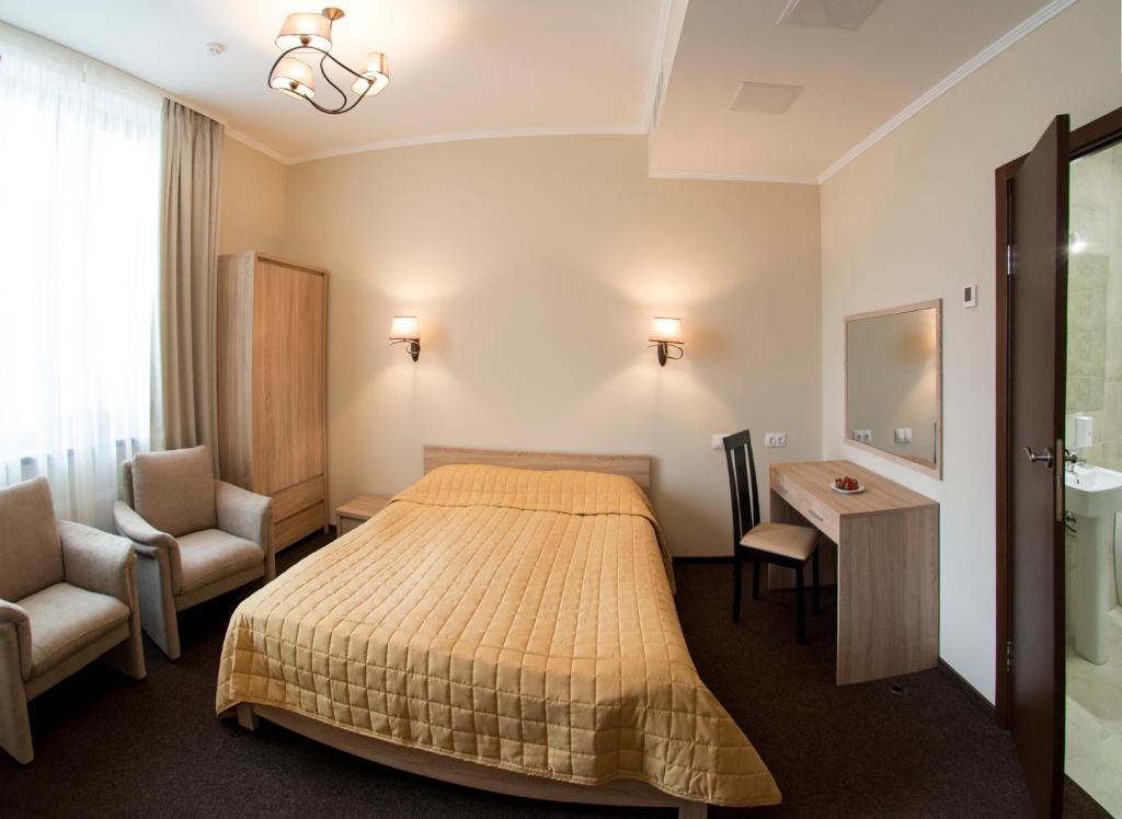 基辅佛罗里达酒店的酒店客房,配有一张床、一张桌子和椅子