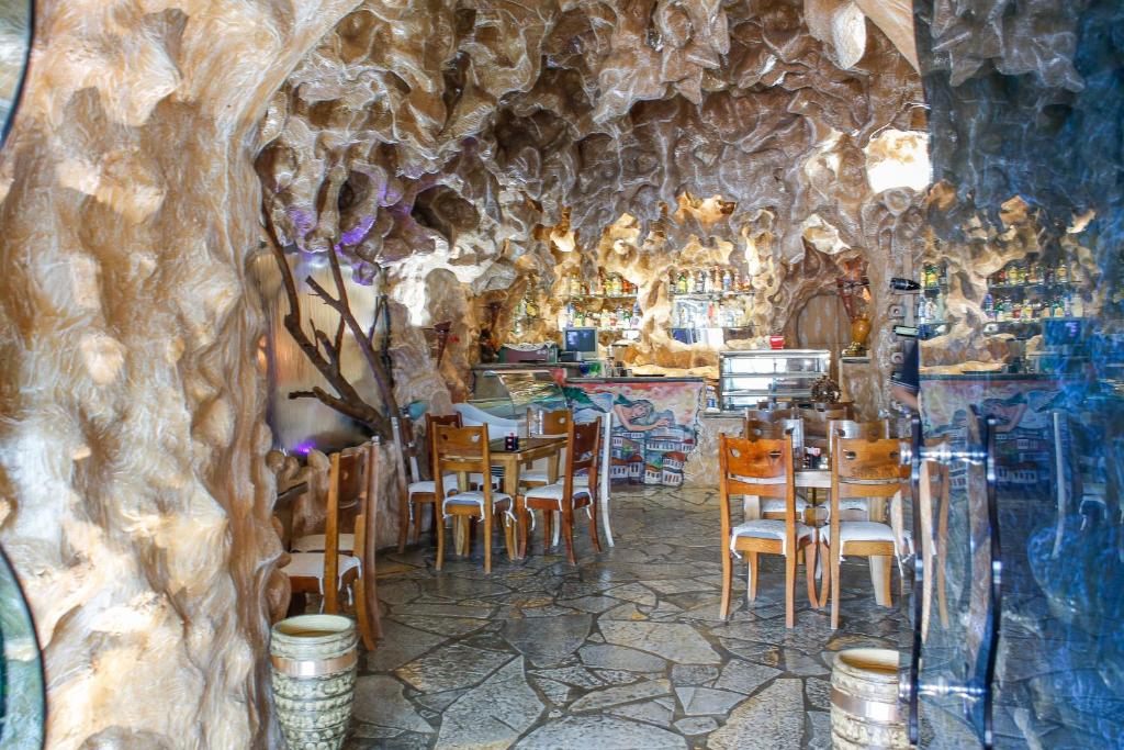 培拉特Hotel Shpella的洞穴内带桌椅的餐厅