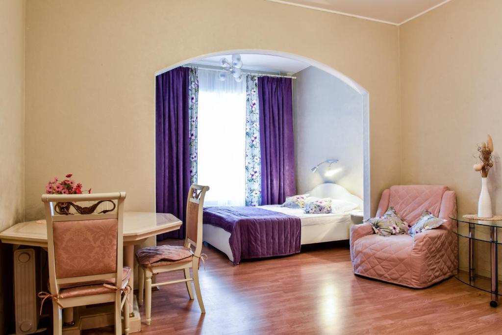 圣彼得堡涅夫斯基酒店 - 涅夫斯基100的卧室配有床、椅子和窗户。
