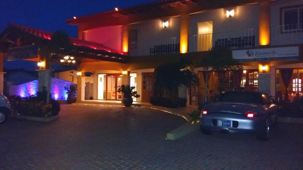棕榈滩Dorado Eagle Beach Hotel的夜间停在大楼前的汽车