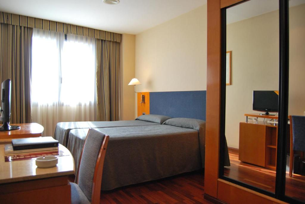 瓦伦西亚维拉卡洛斯酒店的酒店客房,配有床和电视