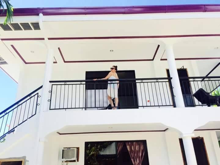 曼巴豪帕布度假屋的站在建筑物阳台上的妇女